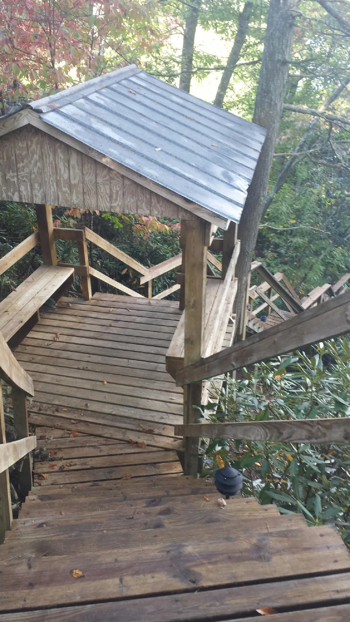 Metal roofed shelter over wooden steps on a wooded walkway — Skylight Repair & Installation work by our crew in Wantagh