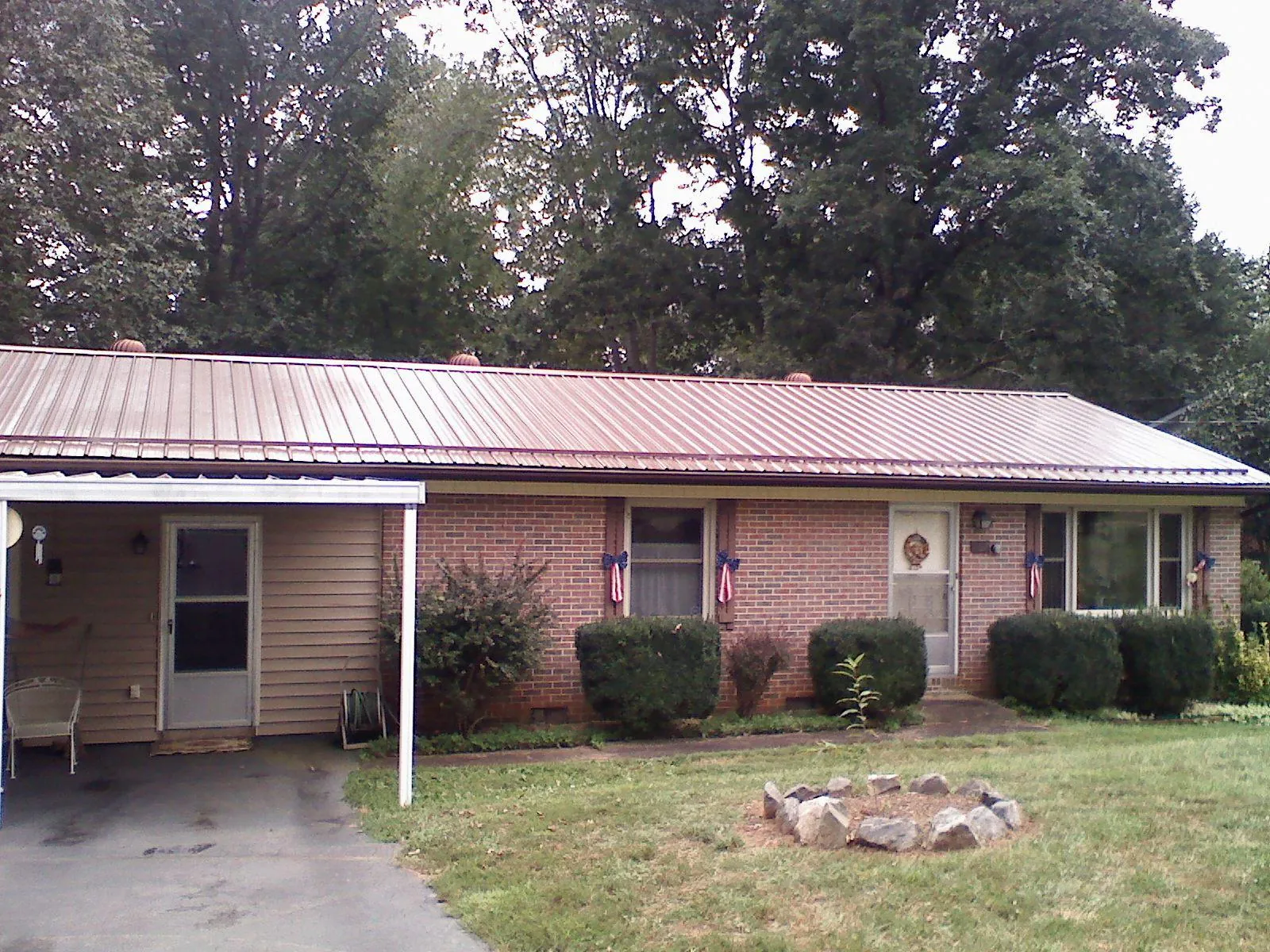 Bronze metal roof and carport on a brick ranch home — Roof Repair work by our crew in Wantagh